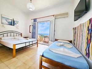 1 dormitorio con 2 camas y vistas al océano en Galini Studios, en Marathokampos