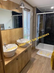 a bathroom with two sinks and a large mirror at Trinity lodge hot tub escapes at Tattershall lakes in Tattershall