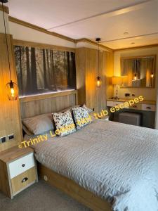 a bedroom with a large bed and a window at Trinity lodge hot tub escapes at Tattershall lakes in Tattershall