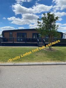 Una señal que lee la sedienta escapada de lodo caliente del lodge en Trinity lodge hot tub escapes at Tattershall lakes, en Tattershall