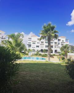 un grand bâtiment avec une piscine et des palmiers dans l'établissement Maha Beach Cabo Negro, à Cabo Negro