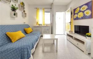 a living room with a blue couch and a tv at Cozy Apartment In Vinaroz With Kitchen in Vinarós