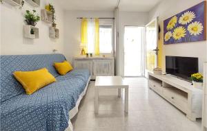 a living room with a blue couch and a tv at Cozy Apartment In Vinaroz With Kitchen in Vinaròs