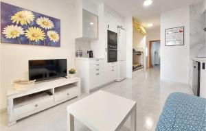 a white living room with a television and a table at Cozy Apartment In Vinaroz With Kitchen in Vinaròs