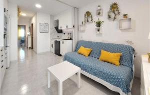 a living room with a blue couch and a table at Cozy Apartment In Vinaroz With Kitchen in Vinarós