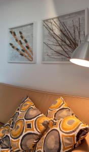 un sofá con 2 almohadas y 2 cuadros en la pared en Apart Great Sea View, en Alvor