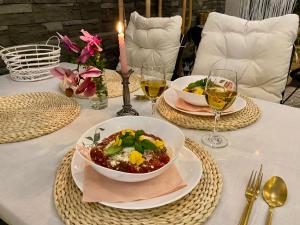 斯塔拉里斯拉的住宿－Vila GARUFA Wellness & Spa，一张桌子,上面放着两盘食物和两杯葡萄酒