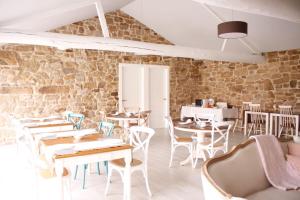 a restaurant with tables and chairs and a brick wall at CASA DA LABORA in Villanueva de Arosa