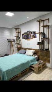 a bedroom with a large bed and some shelves at Casa lazer completo 200m da praia in Praia Grande