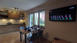 クリニツァ・モルスカにあるSUN CITY Apartament GOSIA - Krynica Morskaのリビングルーム(テーブル、壁掛けテレビ付)