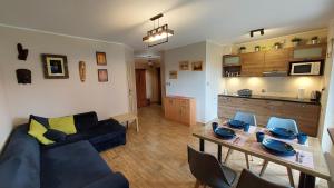 クリニツァ・モルスカにあるSUN CITY Apartament GOSIA - Krynica Morskaのリビングルーム(青いソファ、テーブル付)