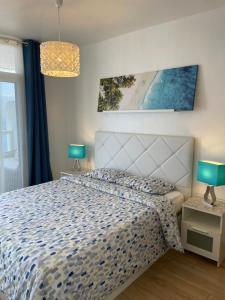 Schlafzimmer mit einem Bett mit einer blauen und weißen Bettdecke in der Unterkunft Blue relax Tabaiba in Tabaiba