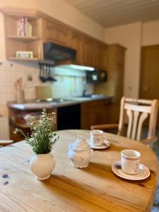 einen Holztisch mit zwei Tassen und Untertassen darauf in der Unterkunft Ferienwohnung Schmidtalien in Dommitzsch