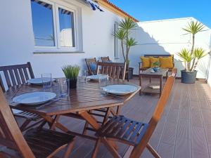een houten tafel en stoelen op een patio bij Moliceiros Torreira in Torreira