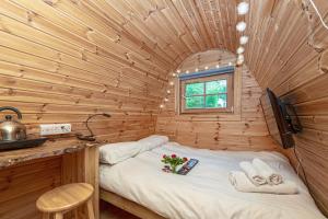 um pequeno quarto com uma cama num chalé de madeira em Nyth Y Goedwig em Dolgellau