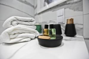 een badkamer met een handdoek en een fles cosmetica bij PORT19 in Wrocław