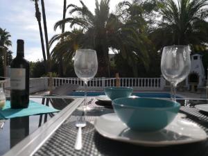 a table with two glasses and a bottle of wine at private Villa mit eigenem Pool unter Palmen in Cala Llenya