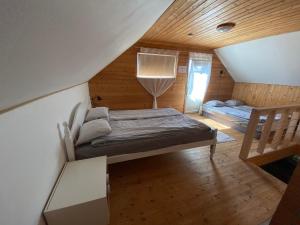 a attic room with a bed and a staircase at Mooni Cottage in Pärnu