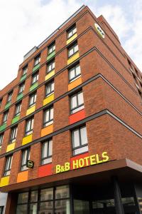 un grand bâtiment en briques avec un panneau d'hôtels bbb dans l'établissement B&B HOTEL Namur, à Namur