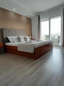 ein Schlafzimmer mit einem großen Bett und einem großen Fenster in der Unterkunft Villa Roso in Kaštela