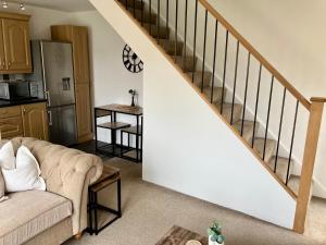 a living room with a couch and a staircase at Central, Cosy Home with Large Garden & Parking, Bournemouth in Bournemouth