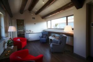 sala de estar con mesa y sillas rojas y azules en El Capricho de Nieves, en Laspuña