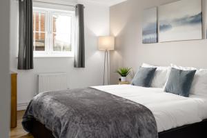 Un dormitorio con una cama grande y una ventana en Charming 2BR Ground Floor Flat in Sholing, 11 Mins from City Centre - Recently Set Up with Love, en Southampton