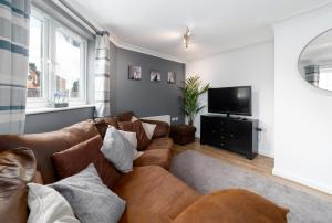 uma sala de estar com um sofá e uma televisão de ecrã plano em Charming 2BR Ground Floor Flat in Sholing, 11 Mins from City Centre - Recently Set Up with Love em Southampton