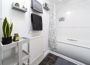 a bathroom with white walls and a shower and a sink at Charming 2BR Ground Floor Flat in Sholing, 11 Mins from City Centre - Recently Set Up with Love in Southampton