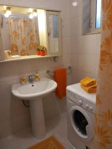 a bathroom with a washing machine and a sink at La Casa Degli Artisti in Veglie
