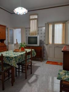 a living room with a table and a television at La Casa Degli Artisti in Veglie