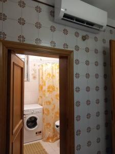 a bathroom with a washing machine and a washer at La Casa Degli Artisti in Veglie +2 photos