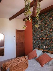 a bedroom with a bed with a floral wall at Hôtel Du Patriarche in Agde