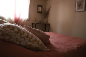 um quarto com uma cama com almofadas e uma janela em Hôtel Du Patriarche em Agde
