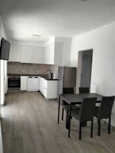 a kitchen with a table and chairs in a room at Casas da Cacilda II in Nazaré