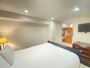 a bedroom with a large white bed and a flat screen tv at COMFY Basement Home 2 Bdrm1Den 3Queen Beds in Washington, D.C.