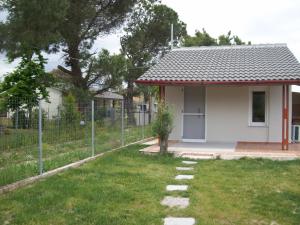una piccola casa bianca con una recinzione nel cortile di ΑΚ Studios Spitaki 3 a Ormos Panagias