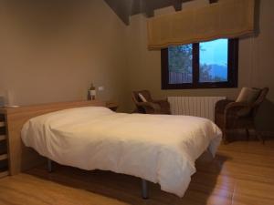 a bedroom with a white bed and a window at Leku eder in Areatza