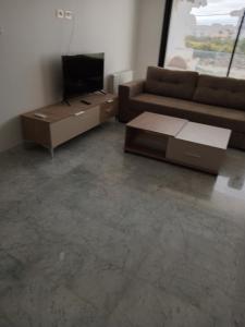 sala de estar con sofá y TV en Residence de la plage en Port El Kantaoui