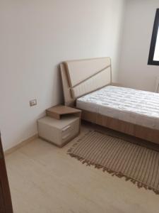 - une chambre avec un lit et une table de chevet à côté dans l'établissement Residence de la plage, à Port El-Kantaoui