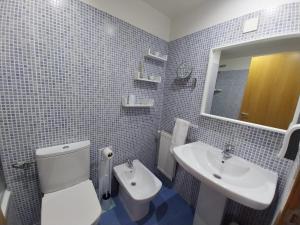 een badkamer met een wit toilet en een wastafel bij Adiva Praia Miño in Miño