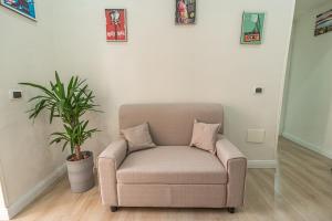 uma cadeira numa sala de estar com uma planta em Casa Vacanze Decumano 18 em Nápoles