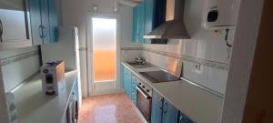 uma cozinha com armários azuis e brancos e um lavatório em Ático en Buenavista playa em Roquetas de Mar