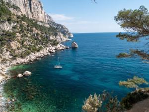 a boat in the water next to a cliff at NEW JOLIETTE Comfortable Apartment well located with private parking in Marseille