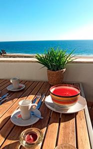 a table with a bowl and a plate of food on it at Apart Great Sea View in Alvor