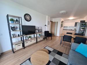 een woonkamer met een bank en een klok aan de muur bij Sky flats Varna with parking in Varna