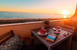 una mesa con tazas y un libro en un balcón con vistas al océano en Apart Great Sea View, en Alvor