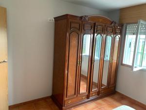 un armario de madera en la esquina de una habitación en Casa Tía María en Villanueva de Arosa