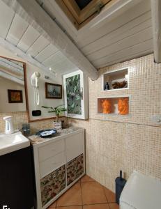 a kitchen with a sink and a tiled wall at La mansarda di Ninni in Catania