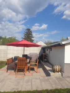 a patio with a table and chairs and an umbrella at Apartman Diana in Boldogkőváralja